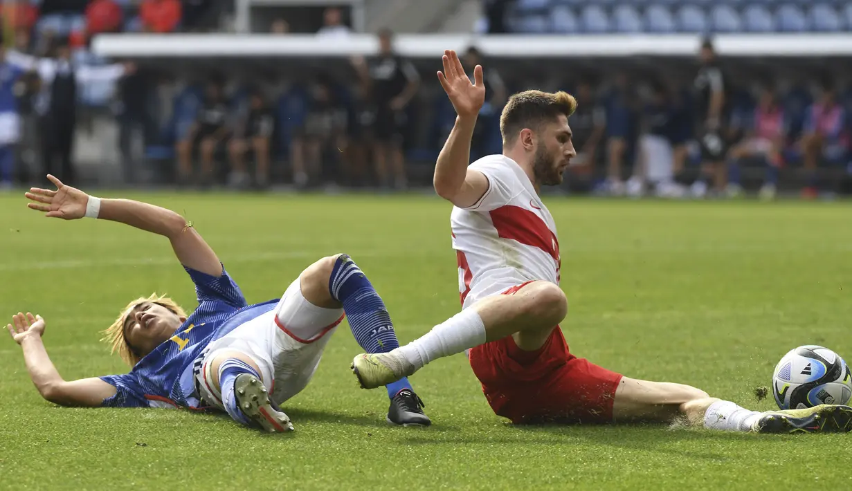Gelandang Timnas Jepang, Junya Ito (kiri) terjatuh setelah dilanggar gelandang Timnas Turki, Ismail Yuksek pada laga persahabatan FIFA Matchday di Luminus Arena, Genk, Belgia, Selasa (12/9/2023) malam WIB. (AP Photo/Frederic Sierakowski)