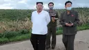 Dalam gambar tak bertanggal yang dirilis 28 Agustus 2020 memperlihatkan pemimpin Korea Utara, Kim Jong-un (kiri) mengunjungi daerah yang dilanda topan di Provinsi Hwanghae Selatan. Kunjungan Kim dilakukan usai televisi pemerintah KCTV menayangkan adegan kerusakan akibat topan. (STR/AFP/KCNA VIA KNS)