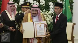Raja Salman memperlihatkan piagam penghargaan yang diperolehnya dari Pemerintah Indonesia di Istana Bogor, Jawa Barat, Rabu (1/2). Raja Salman mendapat penghargaan Bintang Republik Indonesia Adipurna. (Liputan6.com/Angga Yuniar)