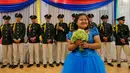 Seorang gadis berpose di depan para tentara selama perayaan ulang tahun massal untuk pasien kanker di Managua, Nikaragua, Sabtu (21/10). Perayaan ultah massal ini diselenggarakan Asosiasi Ibu dan Anak Nikaragua dengan Leukemia dan Kanker. (INTI OCON/AFP)