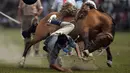 Seorang gaucho atau koboi terjatuh saat menaiki kuda liar pada kompetisi rodeo di San Antonio de Areco , Argentina, Minggu (8/11). Di acara ini, para gaucho saling bersaing menunjukkan keahlian mereka menunggangi kuda liar. (AFP PHOTO / Eitan Abramovich)