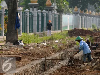 Pekerja merapikan pembuatan saluran air di sekitar trotoar Jalan Gerbang Pemuda Senayan, Jakarta, Kamis (25/8). Pembenahan trotoar di Jalan Gerbang Pemuda dan Asia Afrika, ditargetkan selesai pada akhir 2017. (Liputan6.com/Helmi Fithriansyah)