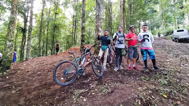 Para penunggang sepeda gunung tengah bersandar menikmati treck kawasan wisata alam Curug Candung, di tengah hutan pinus.
