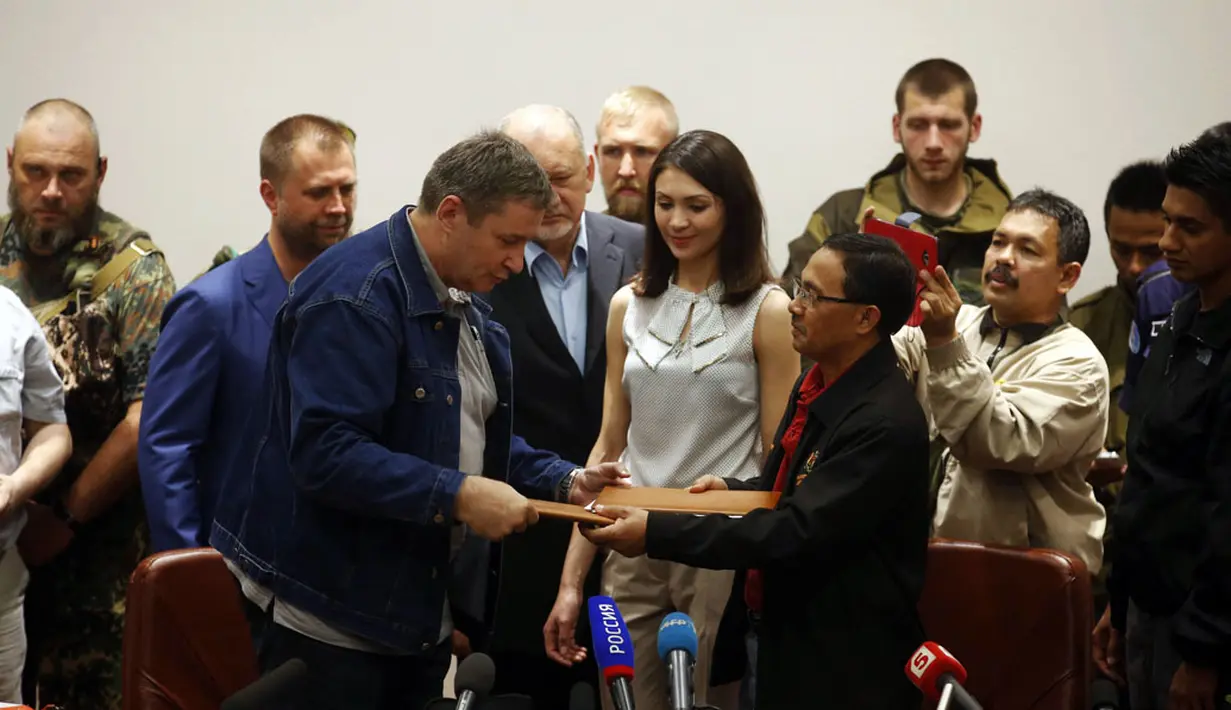 Perwakilan tim investigator Malaysia, Kolonel Mohamed Sakri (kanan - depan) menyerahkan dokumen serah terima kotak hitam pesawat Malaysia Airlines MH-17 di Donetsk, (22/7/2014). (REUTERS/Maxim Zmeyev)