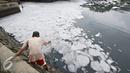 Warga mengambil air dari kali yan tertutup limbah busa, Jakarta, Selasa (16/2). Buruknya tata kelola air di Ibukota menjadi penyebab kondisi Kali Ancol selalu dipenuhi limbah busa, yang merupakan indikator pencemaran air. (Liputan6.com/Immanuel Antonius)