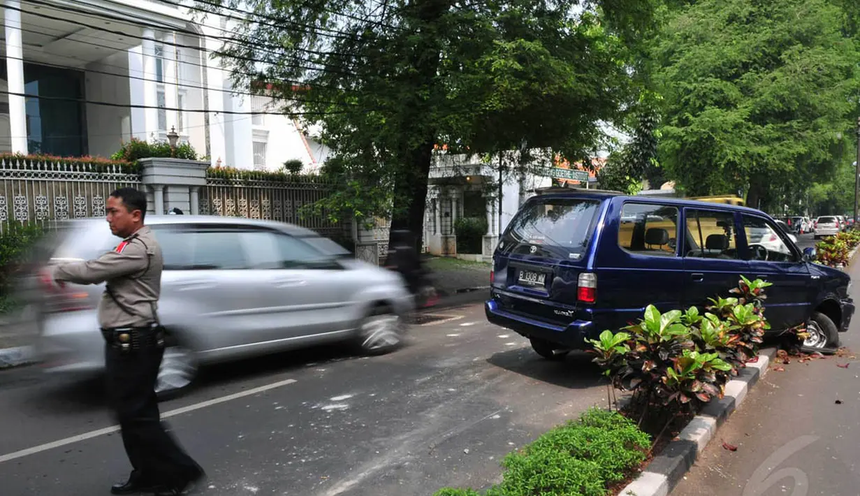  Seorang polisi tampak mengarahkan mobil ke pinggir jalan. (Liputan6.com/Johan Tallo)