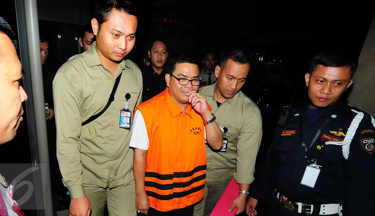 Anggota DPRD Riau periode 2009-2014 Ahmad Kirjauhari dikawal petugas seusai menjalani pemeriksaan di gedung KPK, Jakarta, Rabu (16/9). KPK menahan Ahmad Kirjauhari terkait kasus suap RAPBD Provinsi Riau Tahun 2014-2015. (Liputan6.com/Helmi Afandi)