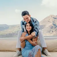 Mike Lewis dan Janissa Pradja tampil  fresh dengan OOTD bertema biru yang cerah, kontras dengan nuansa pegunungan di belakangnya. Tak ketinggalan pelukan mesra darang dari tangan kekar Mike Lewis. (Liputan6.com/IG/@mike_lewis).