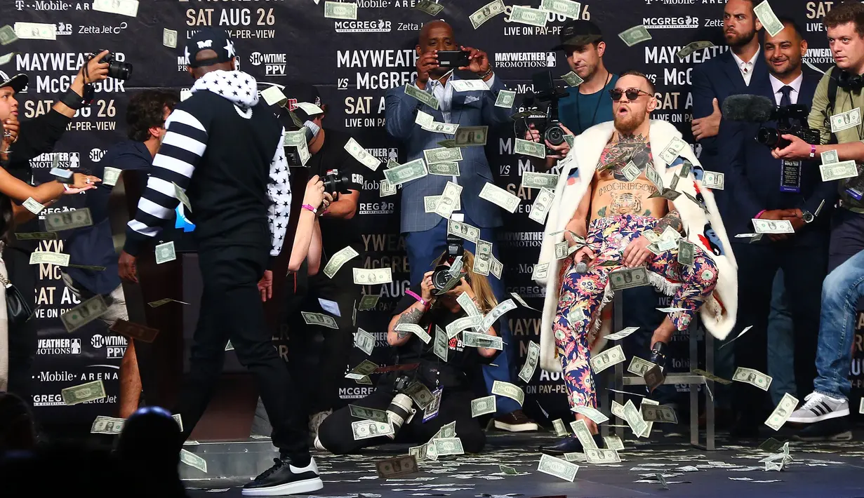 Ekspresi Conor McGregor saat dilemparkan uang petinju Floyd Mayweather saat konferensi pers tur dunia jelang pertandingannya di Barclays Center, Brooklyn, (13/7). Duel ini akan digelar di Las Vegas pada 26 Agustus. (Mike Stobe/Getty Images/AFP)