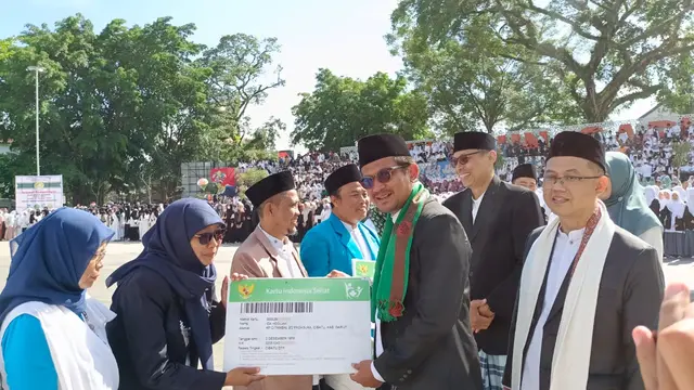 Wabup Garut Helmi Budiman bersama Kepala Kemenag Garut, Cece Hidayat, menyerahkan secara simbolis penghargaan bagi perwakilan kalangan pesantren di puncak kegiatan HSN 2022 di Garut. (Liputan6.com/Jayadi Supriadin)