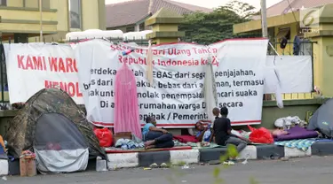 Sejumlah pencari suaka mendirikan tenda di trotoar depan gedung bekas Markas Kodim, Kalideres, Jakarta, Selasa (3/9/2019). Pemprov DKI Jakarta memberikan batas waktu hingga 31 Agustus 2019, namun masih banyak pencari suaka memilih bertahan di gedung itu. (Liputan6.com/Helmi Fithriansyah)