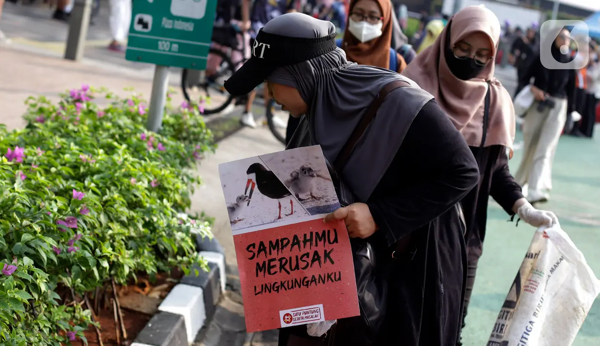 Aksi memunguti puntung rokok di area Hari bebas kendaraan bermotor (HBKB) atau car free day (CFD), kawasan Jalan Sudirman-MH Thamrin, Jakarta, Minggu (28/5/2023). (Liputan6.com/Johan Tallo)