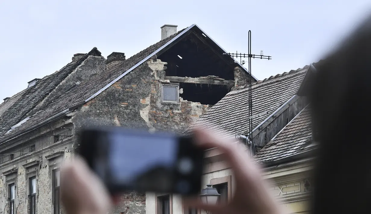 Seorang warga memotret kerusakan akibat gempa bumi di Sisak, Kroasia, Senin (28/12/2020). Gempa memicu kepanikan warga dan beberapa kerusakan di selatan kota. Tidak ada laporan korban luka. (AP Photo)