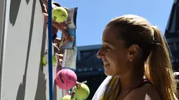 Petenis Slowakia Dominika Cibulkova membubuhkan tanda tangan di bola tenis penggemarnya setelah memenangkan pertandingan putaran kedua Australia Terbuka melawan petenis Taiwan Hsieh Su-Wei di Melbourne, Rabu (18/1). (AFP PHOTO/SAEED KHAN)