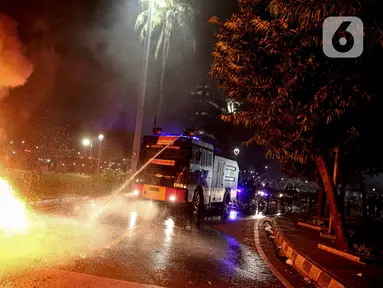 Mobil polisi menyemprotkan air untuk memadamkan api usai demonstrasi yang berujung anarkis di kawasan Bundaran HI, Jakarta, Kamis (8/10/2020). Massa membakar sejumlah barang saat demonstrasi menolak pengesahan UU Cipta Kerja. (Liputan6.com/Faizal Fanani)