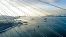 Pekerja menghilangkan es dari kabel Jembatan Russky yang melintasi Selat Bosphorus Timur di Vladivostok, Rusia, Senin (30/11/2020). Jembatan ditutup sementara setelah badai es. (AP Photo/Aleksander Khitrov)