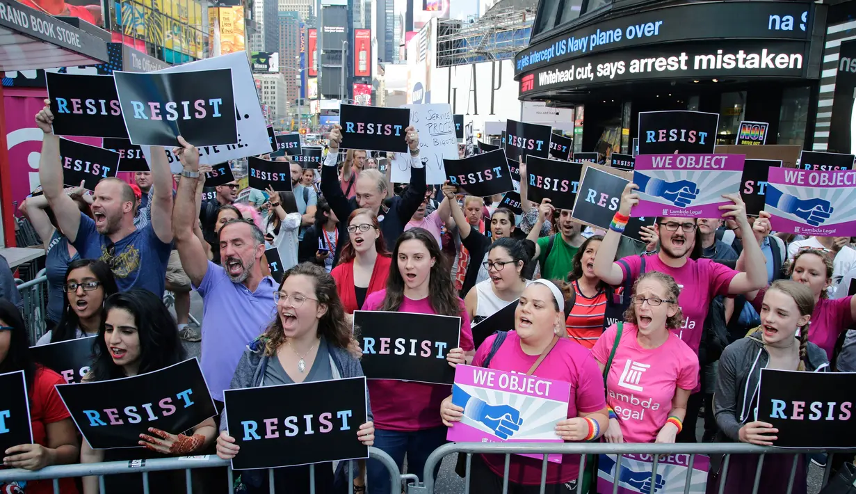 Aksi mengecam Donald Trump terkait larangan transgender masuk militer AS di Times Square, New York, Rabu (26/7). Keputusan Trump menghentikan upaya bertahun-tahun untuk menghilangkan hambatan dinas militer berdasarkan gender. (AP/Frank Franklin II)