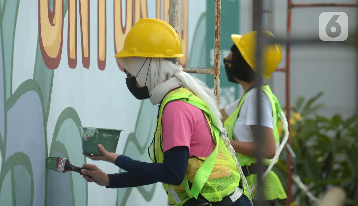 Dua muralis perempuan menyelesaikan pembuatan mural pada dinding di kawasan Juanda, Jakarta, Rabu (16/6/2021). Ini adalah mural ketiga di Jakarta dengan menggunakan cat Graphenstone. (merdeka.com/Imam Buhori)