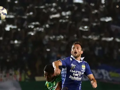 Penyerang Persib, Illia Spasojevic (kanan) berebut bola dengan pemain Persebaya United, Munhar di laga lanjutan Grup A Piala Presiden 2015 di Stadion Si Jalak Harupat, Bandung, Minggu (6/9/2015). Persib unggul 2-0. (Liputan6.com/Helmi Fithriansyah)