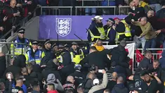 Suporter Hungaria bentrok dengan polisi saat dimulainya laga Kualifikasi Piala Dunia 2022 melawan Inggris di Stadion Wembley, Rabu (13/10/2021) dini hari WIB. Bentrokan terjadi saat polisi berusaha menangkap penonton yang melakukan pelecehan rasial terhadap petugas stadion. (Nick Potts/PA via AP)
