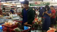 Orang-orang antre untuk membayar makanan dan belanjaan lainnya di supermarket 24 jam di Yangon, Selasa (24/3/2020). Tanggapi kasus pertama Corona COVID-19 pada Senin 23 Maret malam, warga Myanmar memadati pusat perbelanjaan untuk menyetok kebutuhan pokok dan persedian makanan. (AP/Thein Zaw)