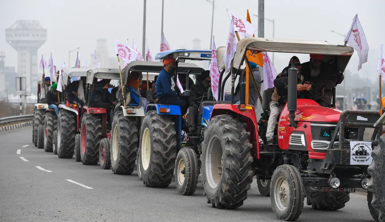 Para petani menaiki traktor berpartisipasi dalam unjuk rasa di Jalan Tol Kundli – Manesar – Palwal (KMP) di Kundli di negara bagian Haryana (7/1/2021). (AFP/Prakash Singh)
