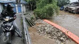 Warga melihat tumpukan sampah yang tertahan di dekat pintu air Manggarai, Jakarta, Rabu (8/3). Hujan deras yang mengguyur kawasan Jabodetabek semalam membuat aliran air Ciliwung meningkat dan membawa sampah. (Liputan6.com/Yoppy Renato)