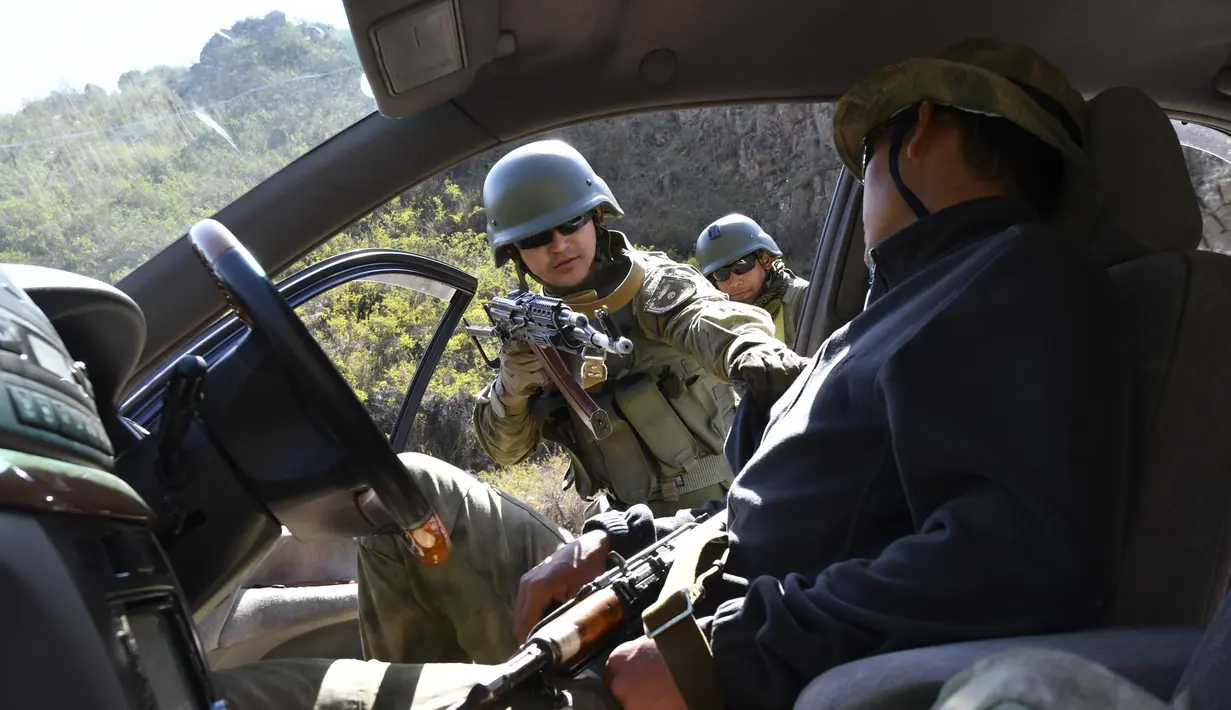 Pasukan menodongkan senjata saat ikut serta dalam latihan gabungan Kyrgyzstan dan India di Ngarai Tatyr, selatan Bishkek, dekat Desa Arashan, Kyrgyzstan, Senin (26/4/2021). Pasukan tersebut berlatih untuk mengoordinasikan aksi mereka melawan militan. (AP Photo/Vladimir Voronin)