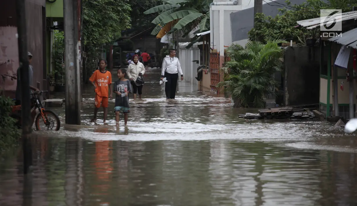 Warga beraktivitas saat banjir merendam kawasan Cipinang Melayu, Jakarta Timur, Senin (5/2). Akibat intensitas hujan yang cukup tinggi, permukiman di wilayah Cipinang Melayu tergenang air setinggi 30-40 cm. (Liputan6.com/Arya Manggala)