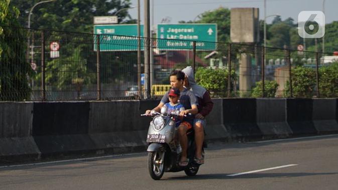 Pengendara motor tanpa mengenakan masker melintas di Kawasan Jakarta, Selasa (19/5/2020). Sanksi PSBB yang kurang tegas menyebabkan sebagian warga masih bebas beraktivitas tanpa menggunakan masker, meskipun resiko penyebaran virus corona masih tinggi. (Liputan6.com/Immanuel Antonius)
