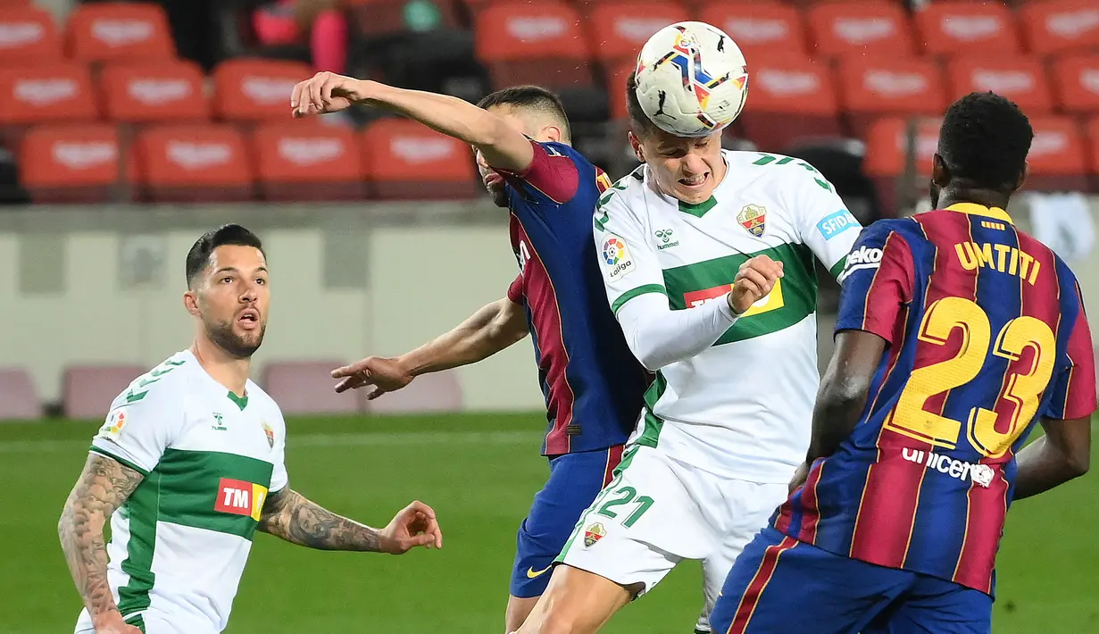 Pemain depan Elche Guido Carrillo (kedua kanan) menyundul bola di antara bek Barcelona Samuel Umtiti (kanan) dan Jordi Alba pada lanjutan Liga Spanyol di Camp Nou, Kamis (25/2/2021) dini hari WIB. Barcelona berhasil kembali ke trek usai menang 3-0 atas Elche. (LLUIS GENE/AFP)