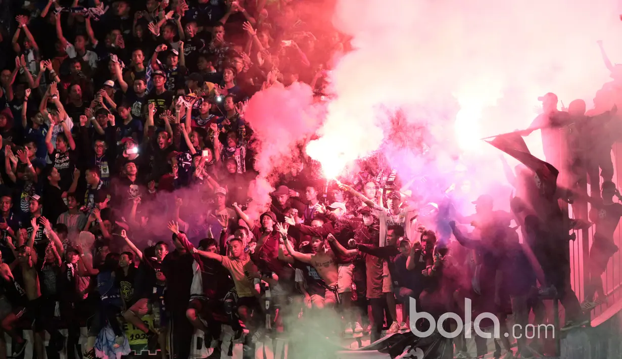 Bobotoh menyalakan flare usai laga Persib Bandung melawan Mitra Kukar pada babak delapan besar Piala Presiden 2017 di Stadion Manahan, Solo. Jumat (25/2/2017). Persib menang 3-2. (Bola.com/Nicklas Hanoatubun)