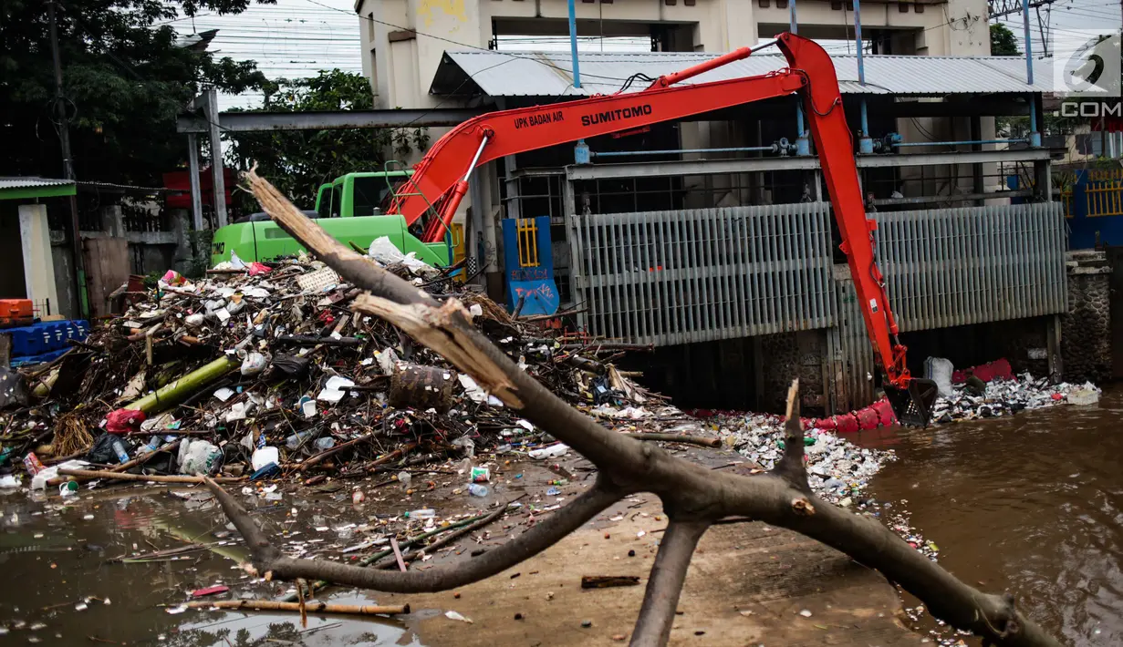 Alat berat beroperasi mengangkut sampah yang menumpuk di Pintu Air Manggarai, Jakarta, Selasa (4/12). Tingginya intensitas hujan di wilayah Jabodetabek membuat sampah yang terbawa arus sungai menumpuk di Pintu Air Manggarai. (Liputan6.com/Faizal Fanani)