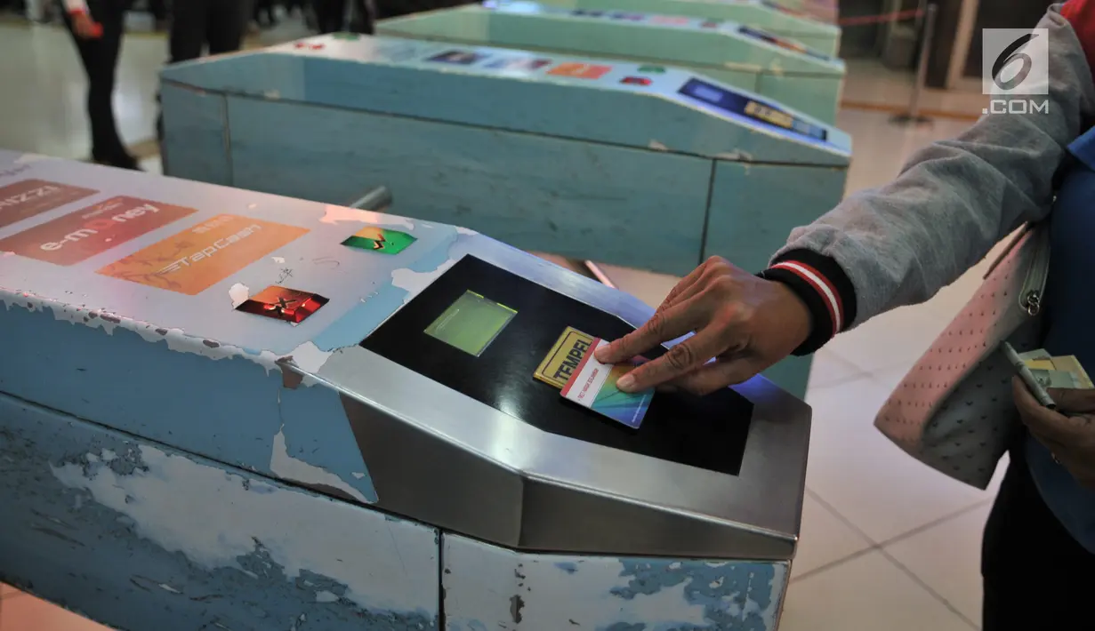 Penumpang saat memindai THB sekali perjalanan pada pintu masuk Stasiun Sudirman, Jakarta, Rabu (17/7/2019). Pembayaran dengan KMT, THB PP dan kartu uang elektronik dapat digunakan di Stasiun Sudirman, Palmerah, Cikini, Universitas Indonesia, dan Taman Kota. (merdeka.com/qbal S. Nugroho)