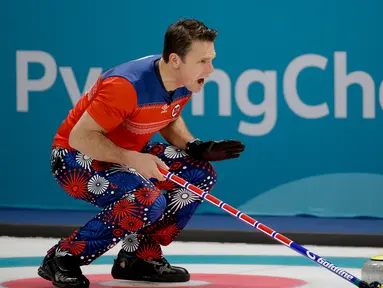 Atlet curling asal Norwegia, Thomas Ulsrud tampil bertanding melawan Denmark pada perhelatan Olimpiade Musim Dingin Pyeongchang 2018, Minggu (18/2). Atlet curling tersebut mengenakan celana bergambar bunga putih, merah dan biru. (AP/Natacha Pisarenko)