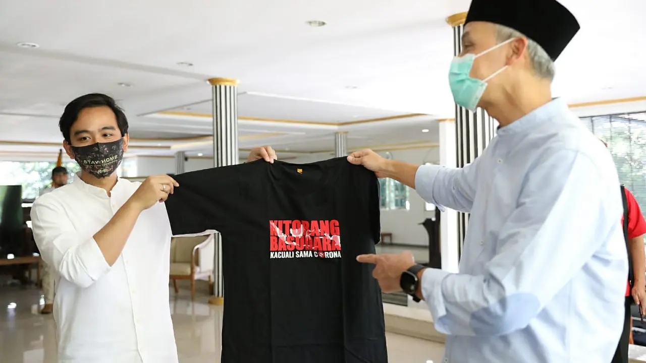 Gibran menyerahkan kaos kepada Ganjar Pranowo. (Foto: Liputan6.com/Felek Wahyu)