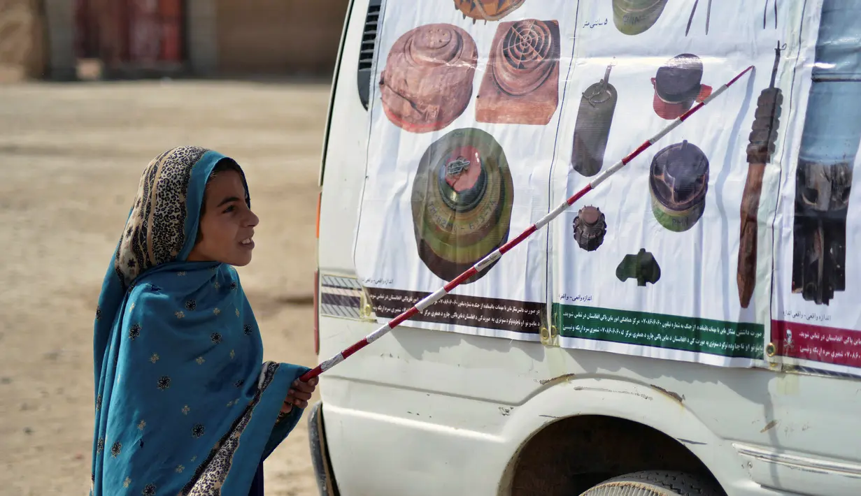 Seorang anak mengikuti kelas tentang risiko ranjau oleh Organisasi penjinak ranjau HALO Trust di desa Nad-e-Ali, provinsi Helmand pada 9 November 2021. Sekitar 41.000 warga sipil Afghanistan terbunuh atau terluka oleh ranjau darat dan persenjataan yang tidak meledak sejak 1988. (Javed TANVEER/AFP)