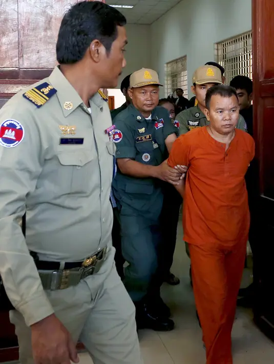 Yem Chrin (kanan) saat memasuki  ruangan sidang di Pengadilan Provinsi Battambang,Kamboja,Kamis (3/12). Diduga dalam prakteknya Yem Chrin menggunakan obat tak berlisensi, suntik bekas dan melakukan malpraktek. (REUTERS/Stringer)