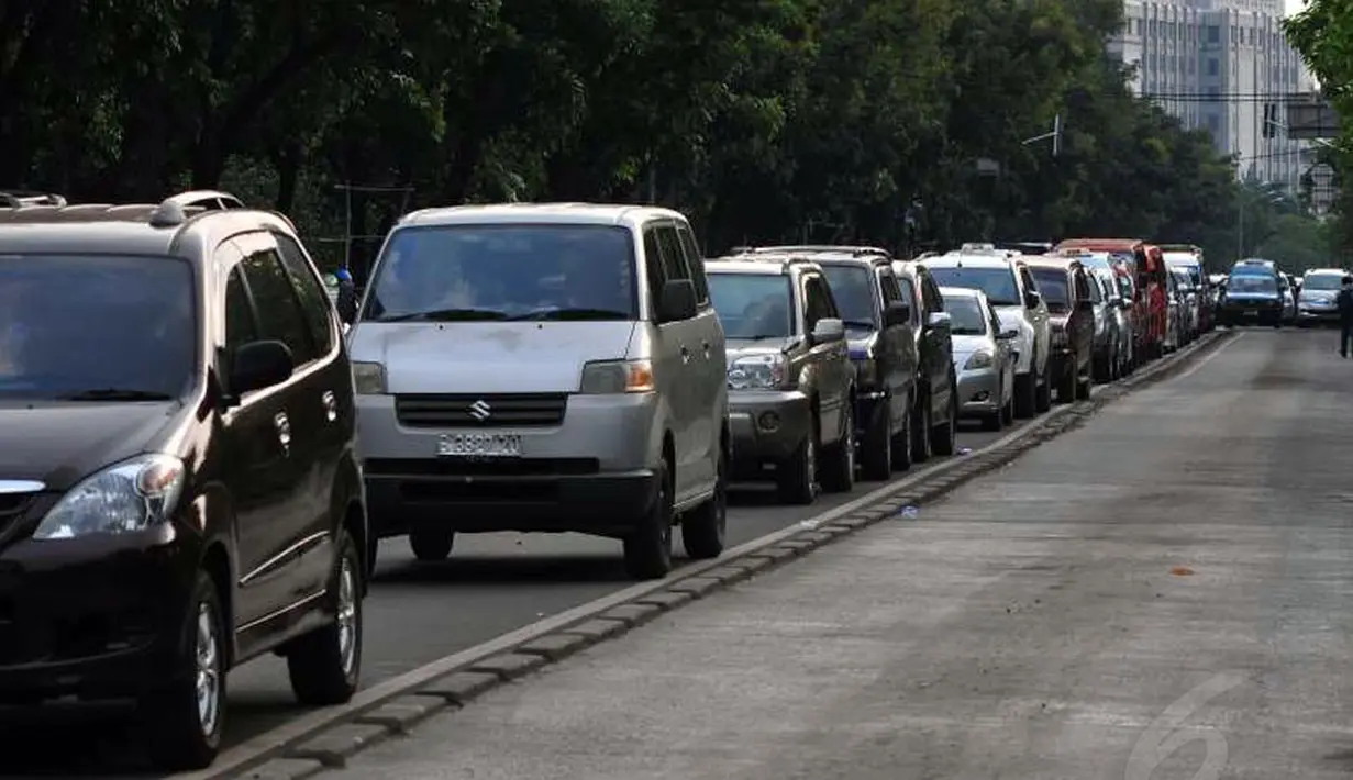 Tingginya minat masyarakat berwisata ke Monumen Nasional, Jakarta, (30/7/2014), membuat sejumlah ruas jalan yang ada di sekitar Tugu Monas berubah menjadi tempat parkir. (Liputan6.com/Johan Tallo)