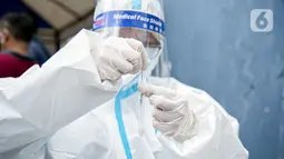 Petugas medis saat melakukan swab antigen terhadap pengungsi banjir di Universitas Borobudur, Cipinang Melayu, Jakarta, Minggu (21/2/2021). Pengungsi diwajibkan menjalani swab antigen untuk mencegah penyebaran COVID-19. (Liputan6.com/Faizal Fanani)
