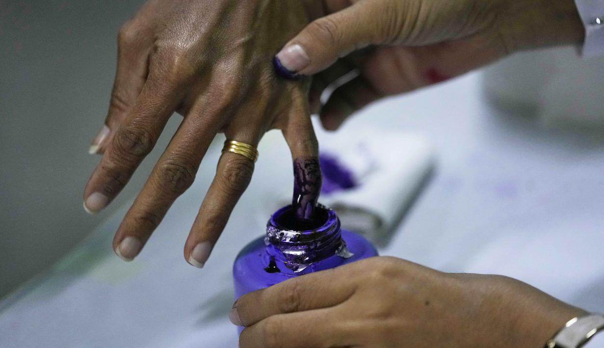 Untuk tahap kedua akan digelar pada 11 Januari 2026. Tampak dalam foto, seorang pemilih mencelupkan jarinya ke dalam botol tinta setelah memberikan suara di tempat pemungutan suara di Naypyitaw, Myanmar, Minggu, 28 Desember 2025. (AP Photo/Aung Shine Oo)