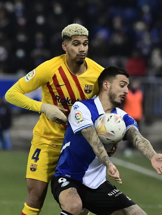Penyerang Deportivo Alaves, Joselu Alaves berebut bola dengan bek Barcelona Ronald Araujo dalam duel pekan ke-22 La Liga 2021/22, di Estadio Mendizorroza, Senin (24/1/2022) dini hari WIB. Gol telat Frenkie De Jong memenangkan Barcelona 1-0. (AP Photo/Alvaro Barrientos)