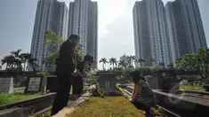 Umat Kristiani tampak berdoa sembari membersihkan makam keluarga dan kerabatnya pada momen Paskah di Menteng Pulo, Jakarta, Minggu (5/4/2015). (Liputan6.com/Faizal Fanani)