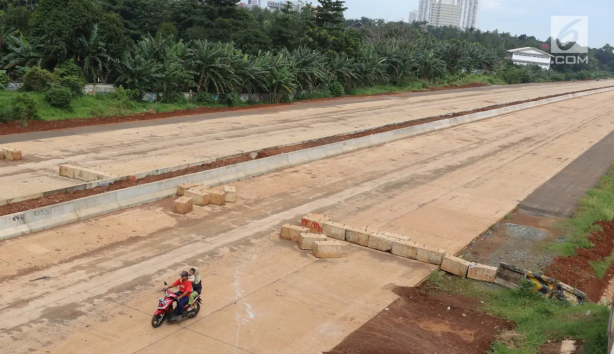 Pengendara melintasi proyek pembangunan Jalan Tol Cijago, Depok, Jawa Barat, Senin (19/2). Panjang 615 Km jalan tol belum ditambah sekitar 220 Km tol yang molor target pengoperasiannya pada tahun lalu. (Liputan6.com/Immanuel Antonius)