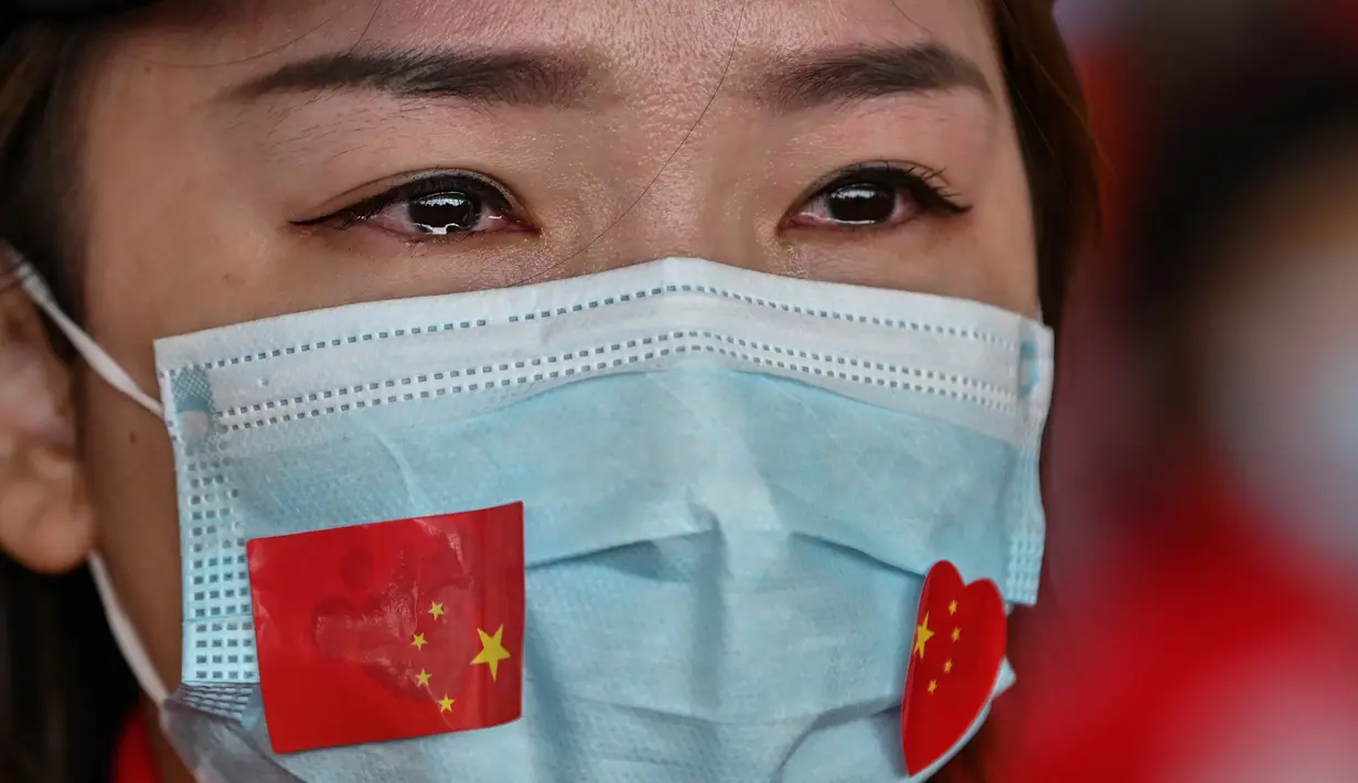 Staf medis dari Provinsi Jilin menangis saat upacara pelepasan setelah menangani pandemi Covid-19 di Bandara Tianhe, Wuhan, provinsi Hubei, Rabu (8/4/2020). Pemulangan staf medis ini bersamaan dengan pencabutan status lockdown di Wuhan yang telah diberlakukan selama 11 minggu. (Hector RETAMAL/AFP)