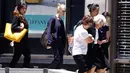 Beberapa orang membantu evakuasi seorang wanita lanjut usia keluar dari gedung yang berada di sebelah kafe Lindt, lokasi terjadinya penyanderaan di Sydney, Australia (15/12/2014). (REUTERS/David Gray)