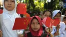 Sejumlah murid menyambut kedatangan PM China Li Keqiang di kawasan Istana Bogor, Senin (7/5). Li akan melakukan pertemuan bilateral dengan Presiden Jokowi membahas proyek pembangunan jaringan kereta api cepat Jakarta-Bandung.  (Merdeka.com/Arie Basuki)