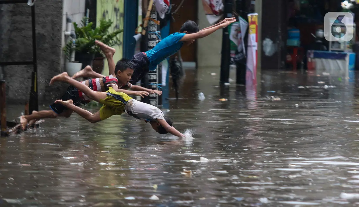 Sejumlah anak bermain saat banjir melanda kawasan Kemang Utara, Jakarta, Kamis (4/1/2024).(Liputan6.com/Herman Zakharia)