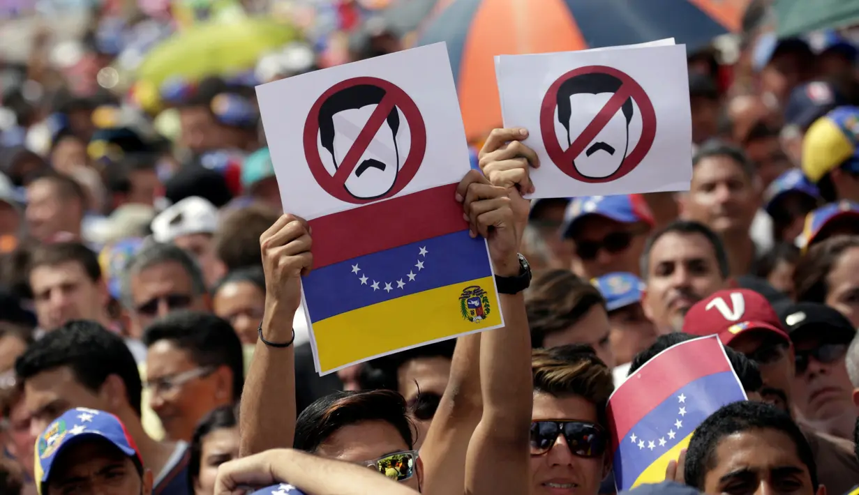 Ribuan pendukung kelompok oposisi turun ke jalan saat unjuk rasa di Caracas, Venezuela (26/10). Aksi unjuk rasa ini tak hanya berlangsung di Caracas, tetapi juga digelar serentak di lokasi lainnya. (REUTERS/Carlos Garcia Rawlins)