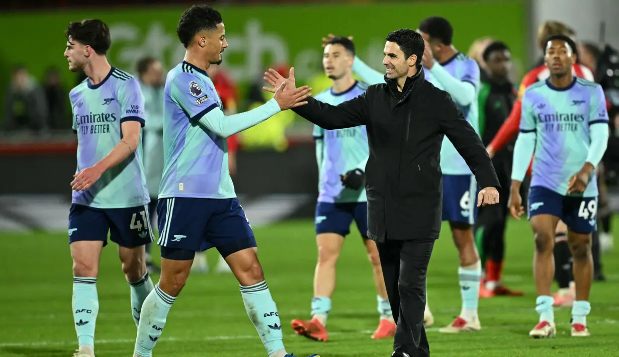 Pelatih Arsenal, Mikel Arteta (tengah) merayakan kemenangan bersama William Saliba pada akhir laga pekan 19 Premier League 2024/2025 melawan Brentford di Stadion Gtech Community, London pada Rabu 1 Januari 2025 waktu setempat atau Kamis 2 Januari 2025 dini hari WIB. (JUSTIN TALLIS/AFP)